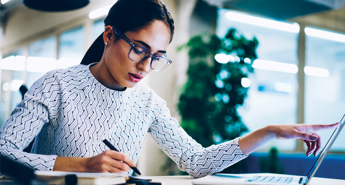 Young businesswoman doing work with laptop next to her