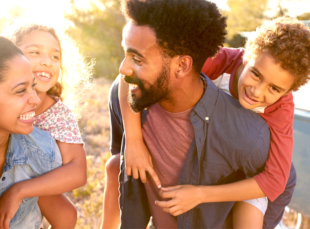 African American parents with children on their backs taking a walk