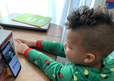 Young boy using smartphone to visit with Santa Claus