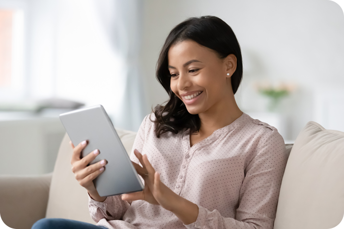 African American woman using smartphone while sitting on couch